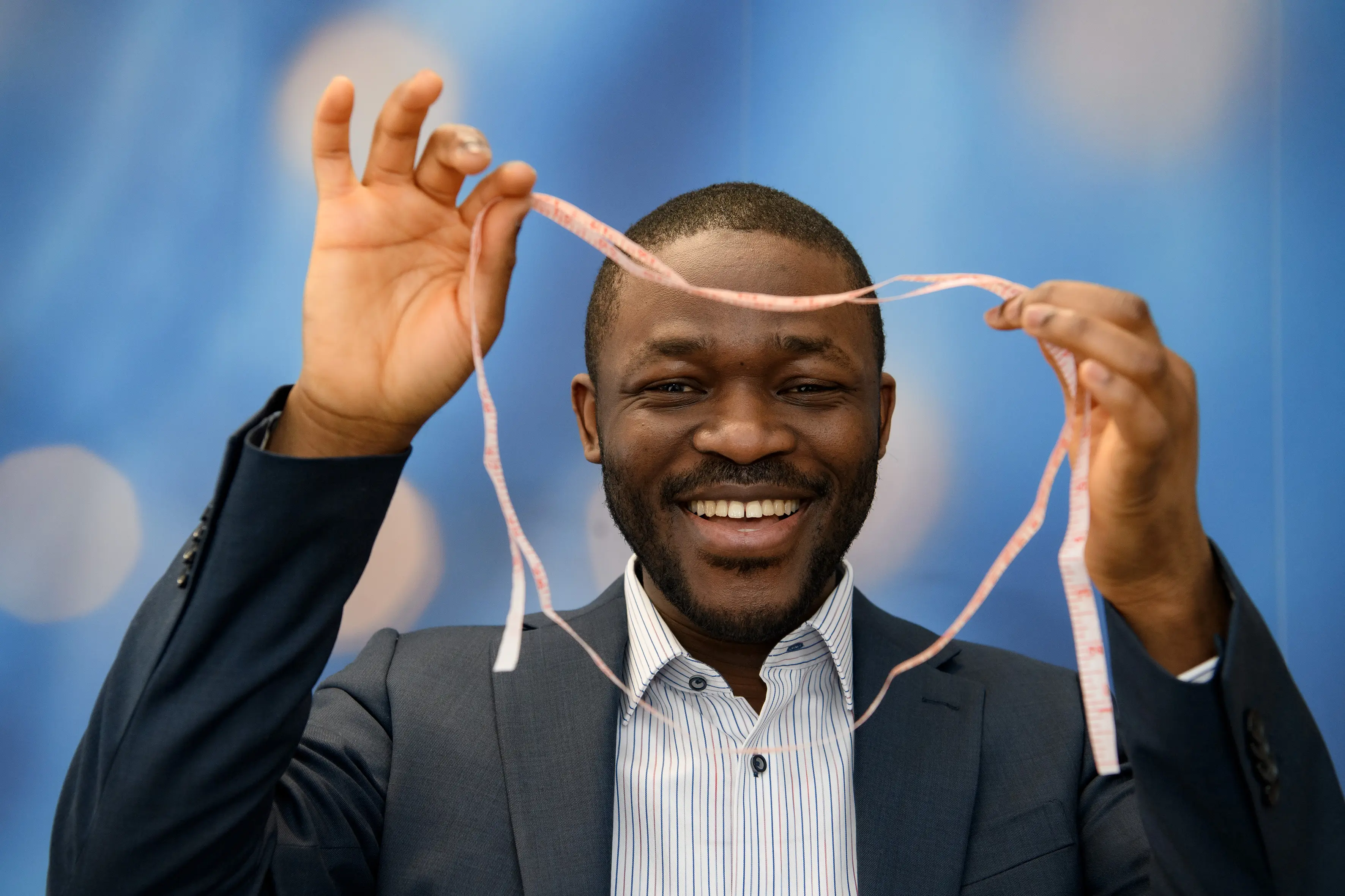 Professor Andrew Agbaje, a leading childhood obesity researcher, demonstrating how to use a waist to height ratio calculator (WHtR) with a measuring tape.